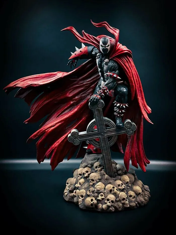 A dramatic 3D printing of Spawn standing on a pile of skulls with a cross, a fan's amazing creation.