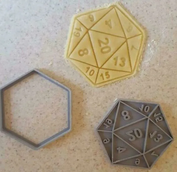 A 3D printing cookie cutter for a twenty-sided die, alongside a cut dough and a grey printed mold.