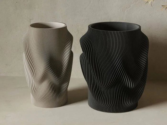 Two textured 3D printing vases, one light and one dark, displaying amazing creations with artistic flair.