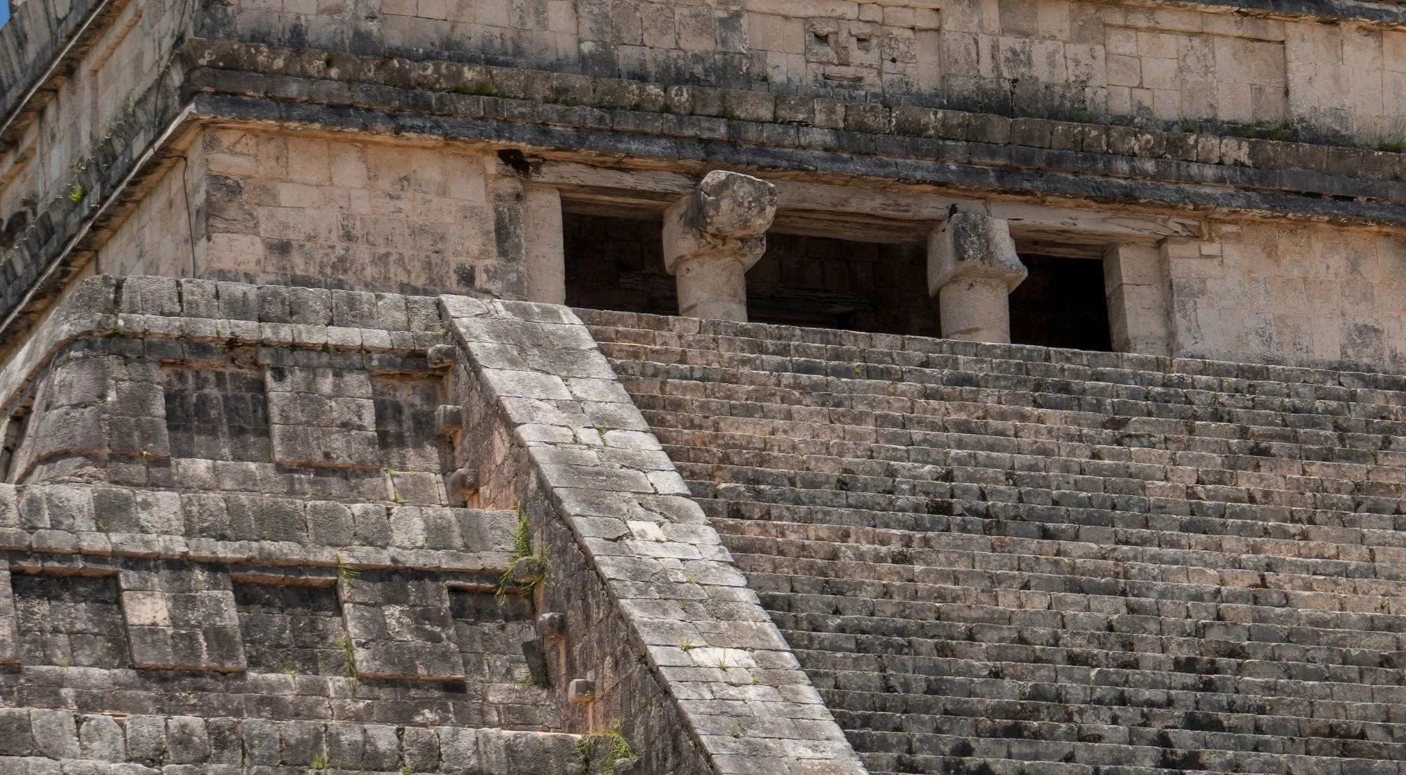 Zoomed in view of the stone steps and top facade of a world-famous landmark, possibly a Mayan temple or pyramid.