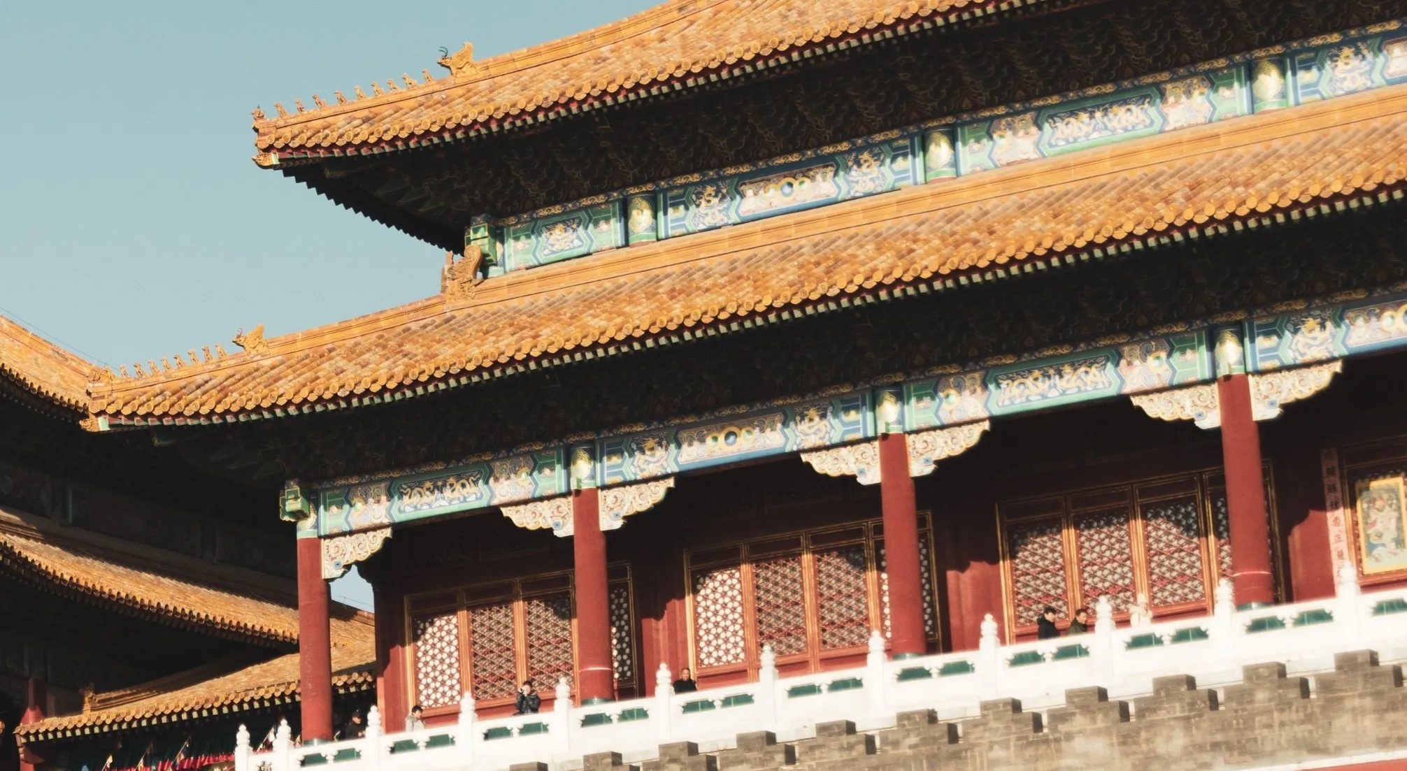 Zoomed-in landmark of a traditional Chinese building with orange tiled roofs, red pillars, and ornate details.