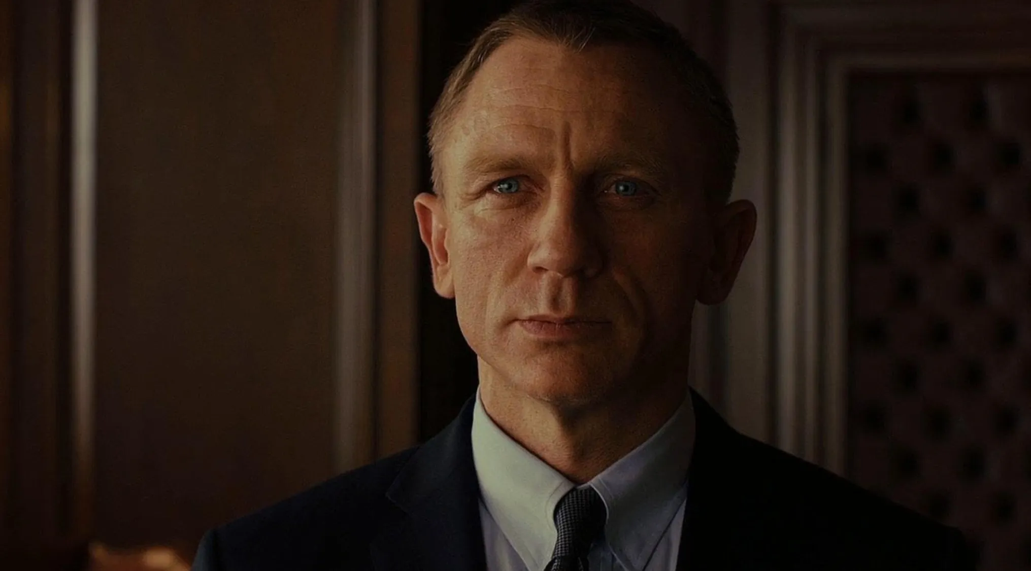 Daniel Craig as James Bond, a film character, looking intently in a dramatic close-up.