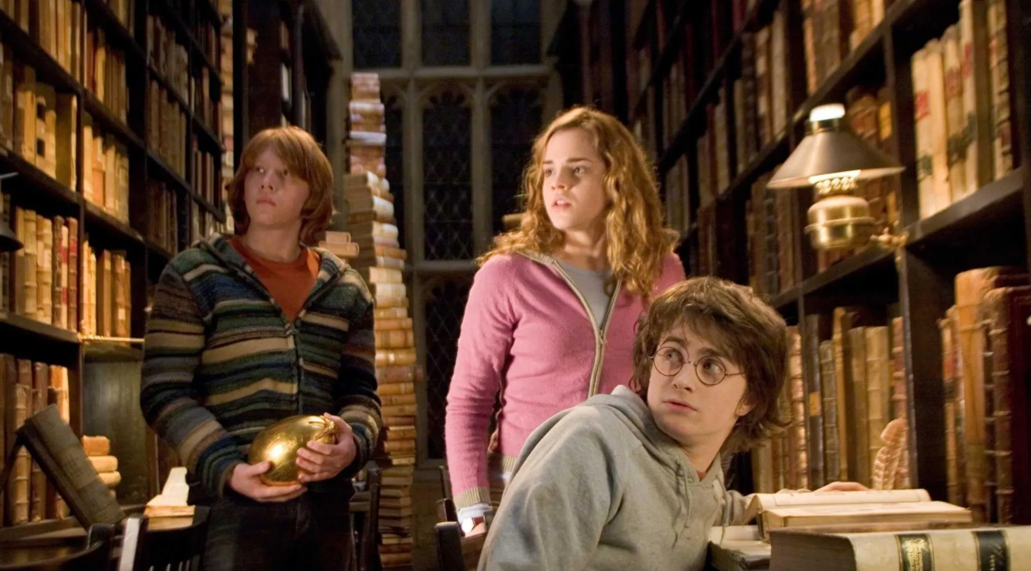 Harry Potter, Hermione, and Ron in a library from a movie franchise, used to identify the odd one out among subtitles.