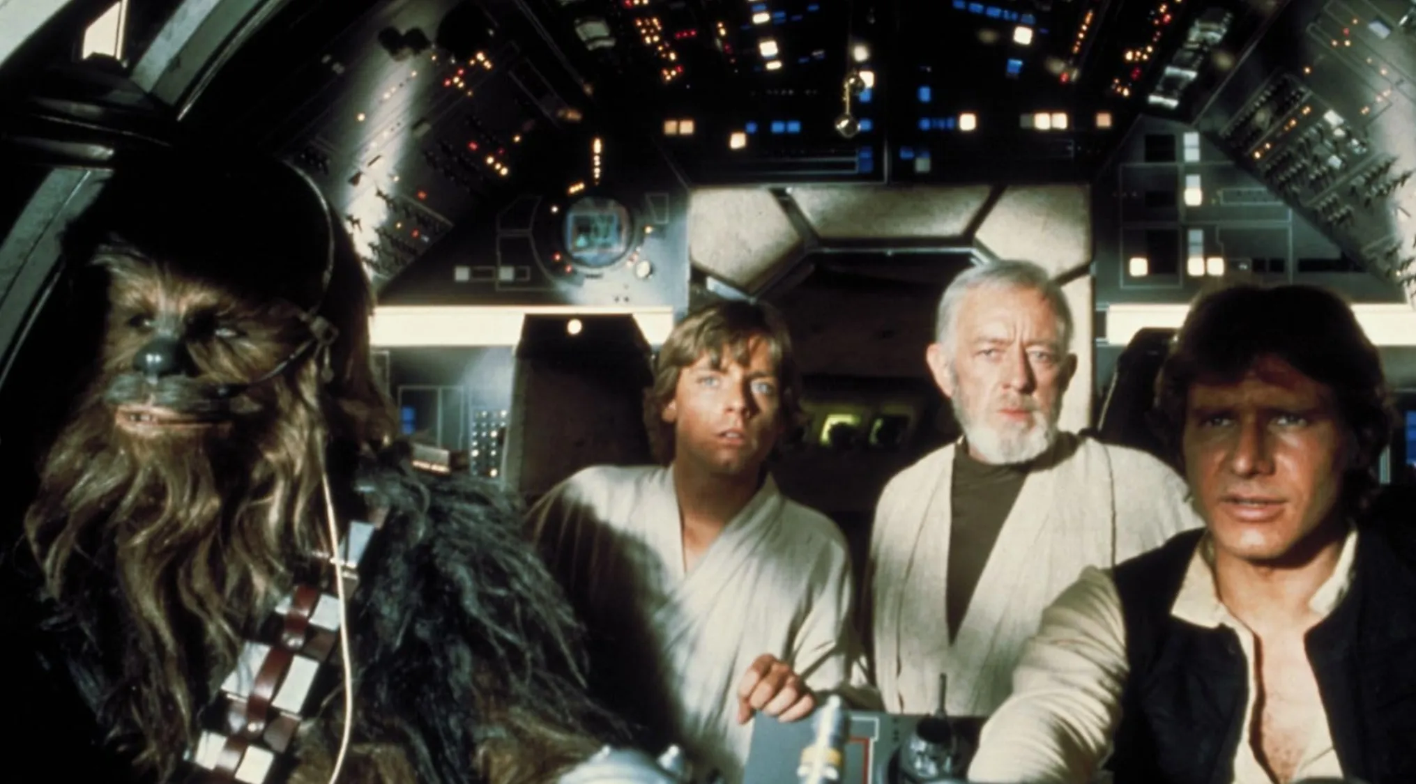 A group of four characters in a cockpit, including Chewbacca, Luke Skywalker, Obi-Wan Kenobi, and Han Solo from Star Wars movie franchises.