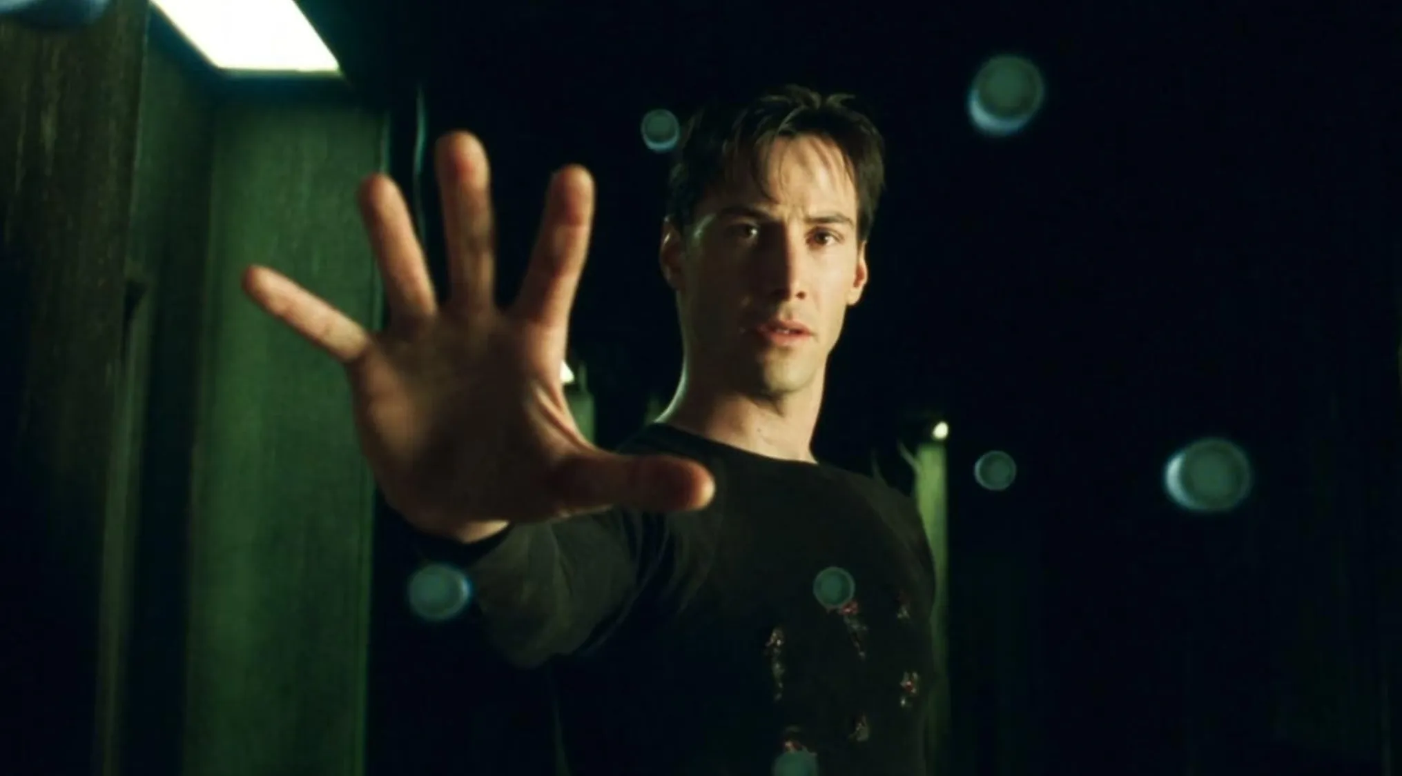 Neo, played by Keanu Reeves, extending his hand, stopping bullets in The Matrix film subtitle.