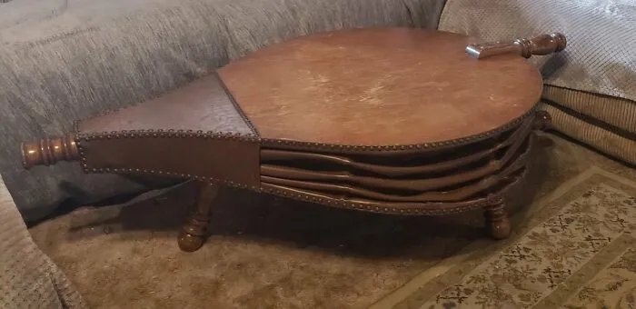 A large wooden bellows-shaped coffee table, a unique and bizarre furniture design.