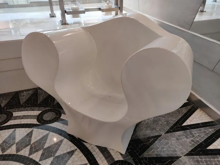 A unique white furniture piece with a curvy design, showcasing bizarre furniture design.