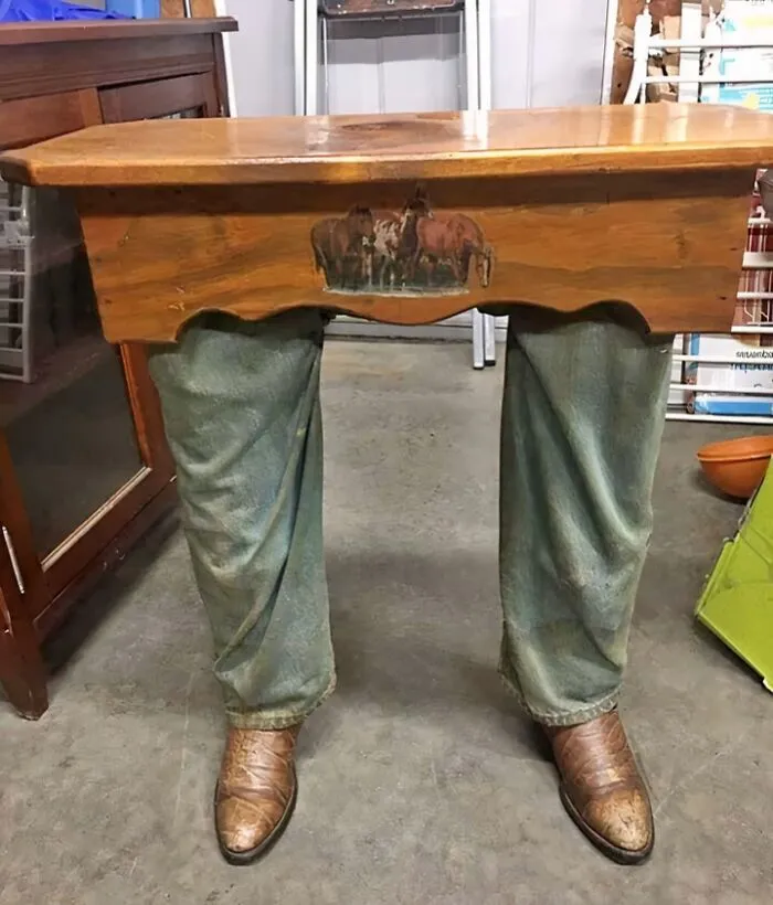 Bizarre furniture design: a table with legs resembling jeans and cowboy boots, a creation from a furniture designer.