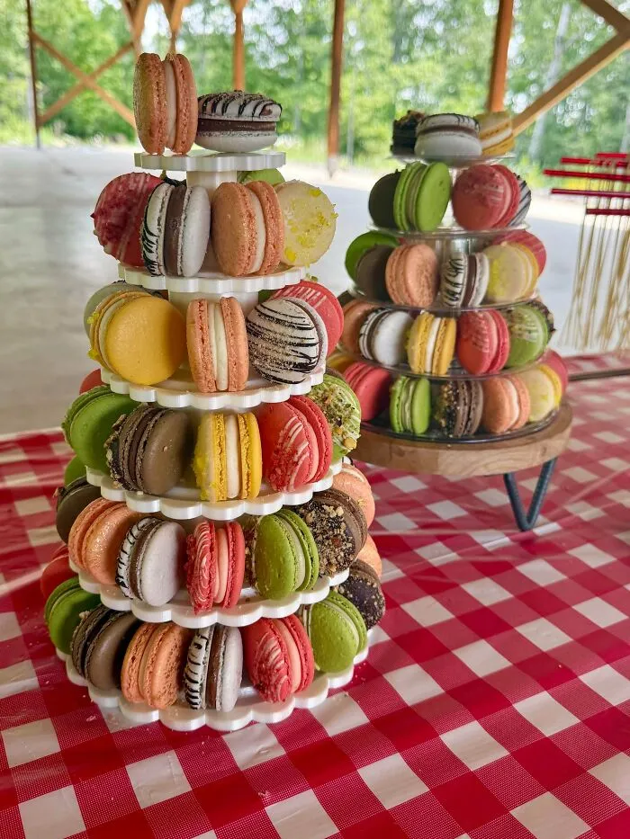 Two amazing baker's towers of colorful macarons, showcasing delicious treats on a red and white checkered tablecloth.