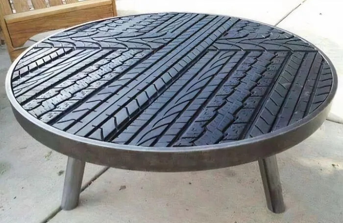 A circular coffee table with its surface made from repurposed tire treads, showcasing unique furniture designers.