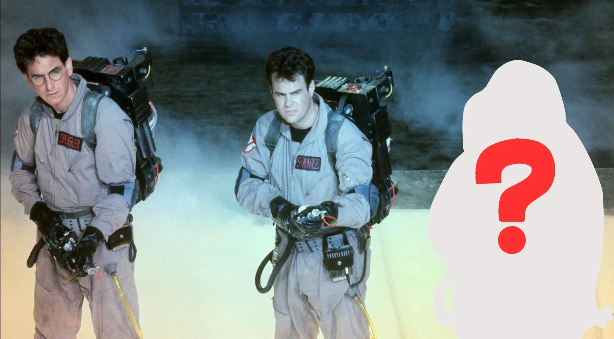 Two Ghostbusters, Spengler and Stantz, pose with proton packs next to a blank silhouette with a red question mark for the missing actor.