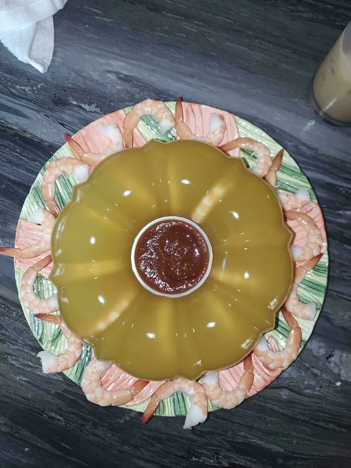 A gelatin mold with shrimp and cocktail sauce, appearing as disgusting food that deserves to be shamed.