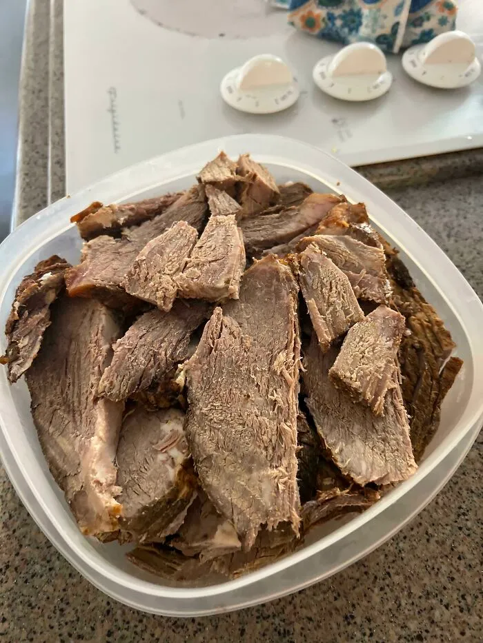 A container of dull, sliced meat with a dry texture, appearing unappetizing and truly disgusting food.