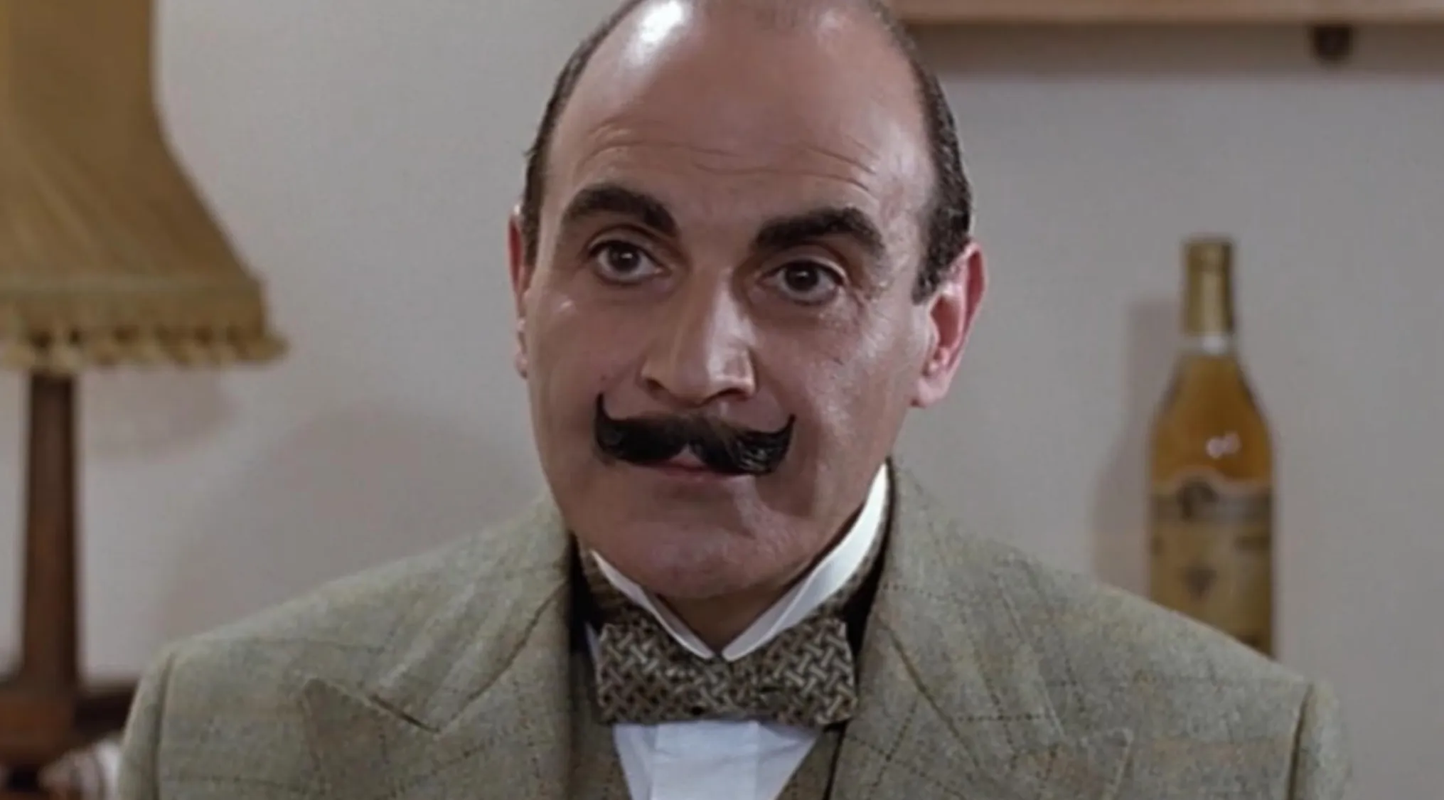 A man portraying detective Hercule Poirot with a distinct mustache and bow tie. How well-read are you?