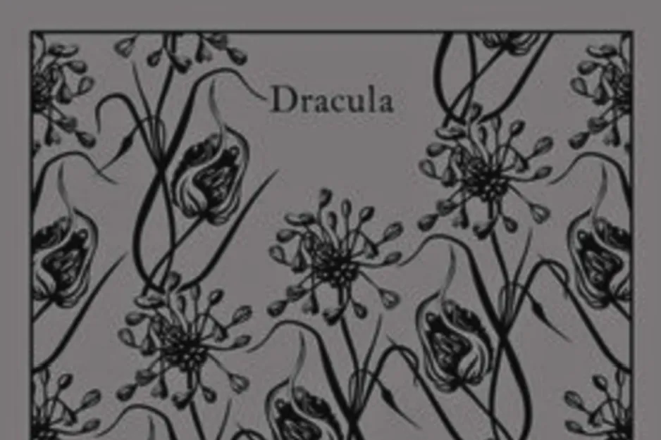 Dracula book cover with a pattern of dark flowers on a gray background.