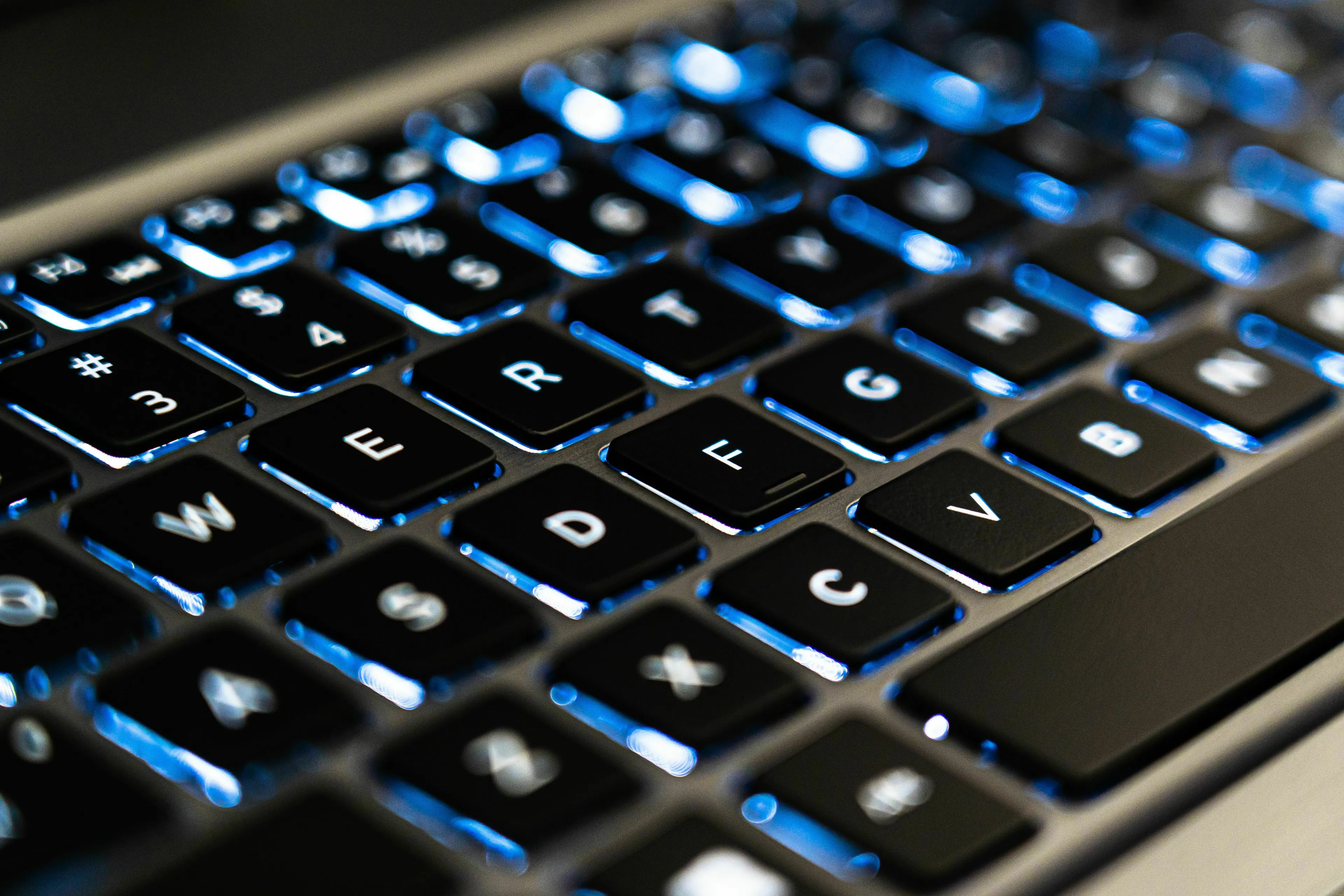 Close-up of a computer keyboard with illuminated keys, highlighting the F and J key bumps.