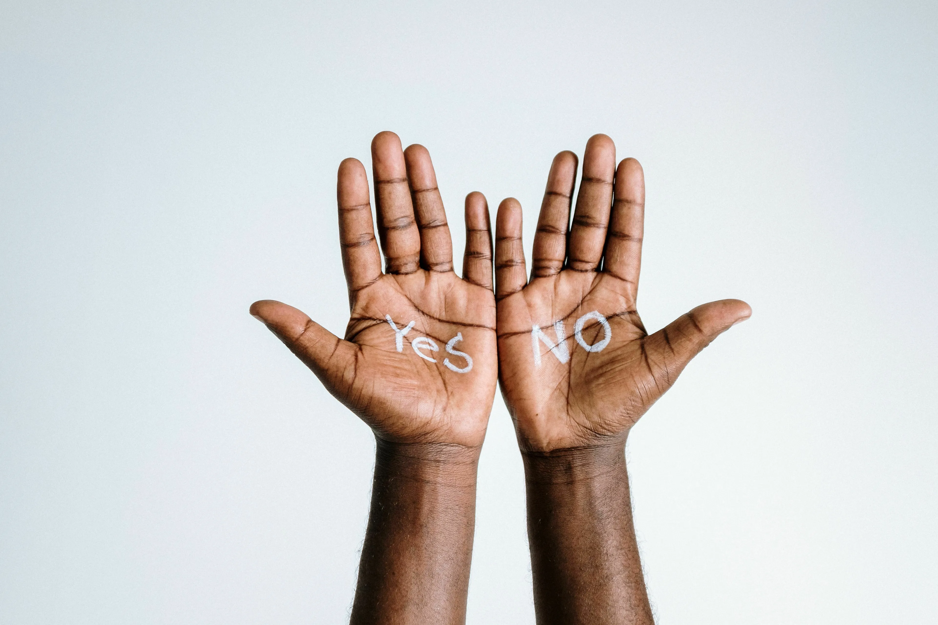 Hands with Yes and No written on the palms, illustrating decision-making for an unresolved mystery.