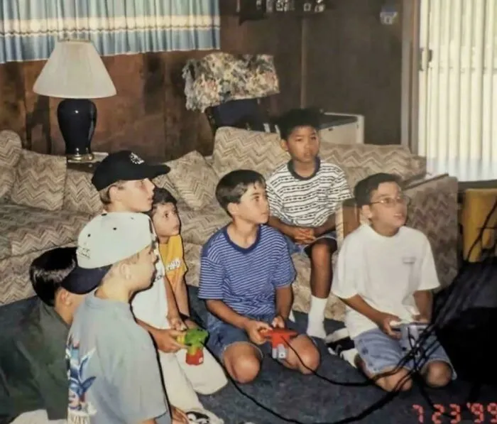 A group of kids playing video games on the floor, experiencing life in the 90s.