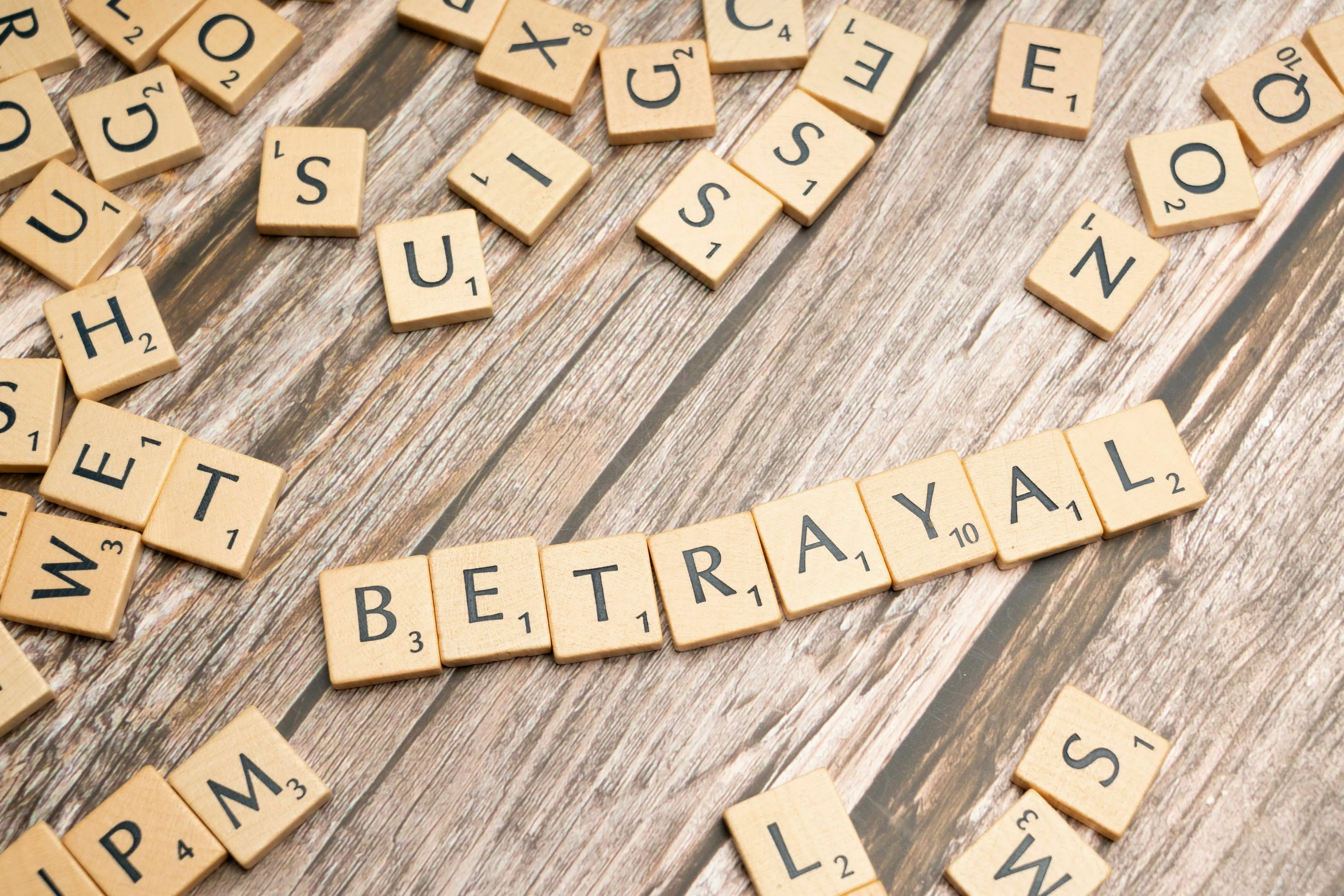 Scrabble tiles spelling out BETRAYAL, illustrating the instinctual reaction of a movie villain.