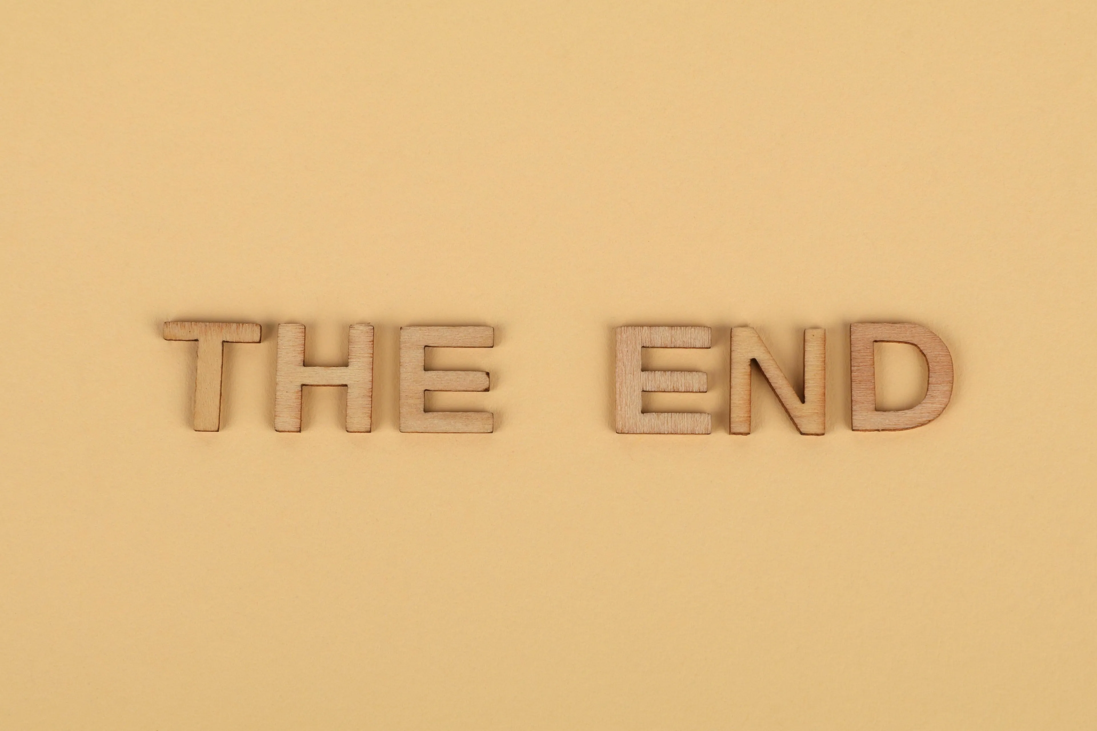 The words THE END spelled out in wooden letters on a beige background represent a movie ending.