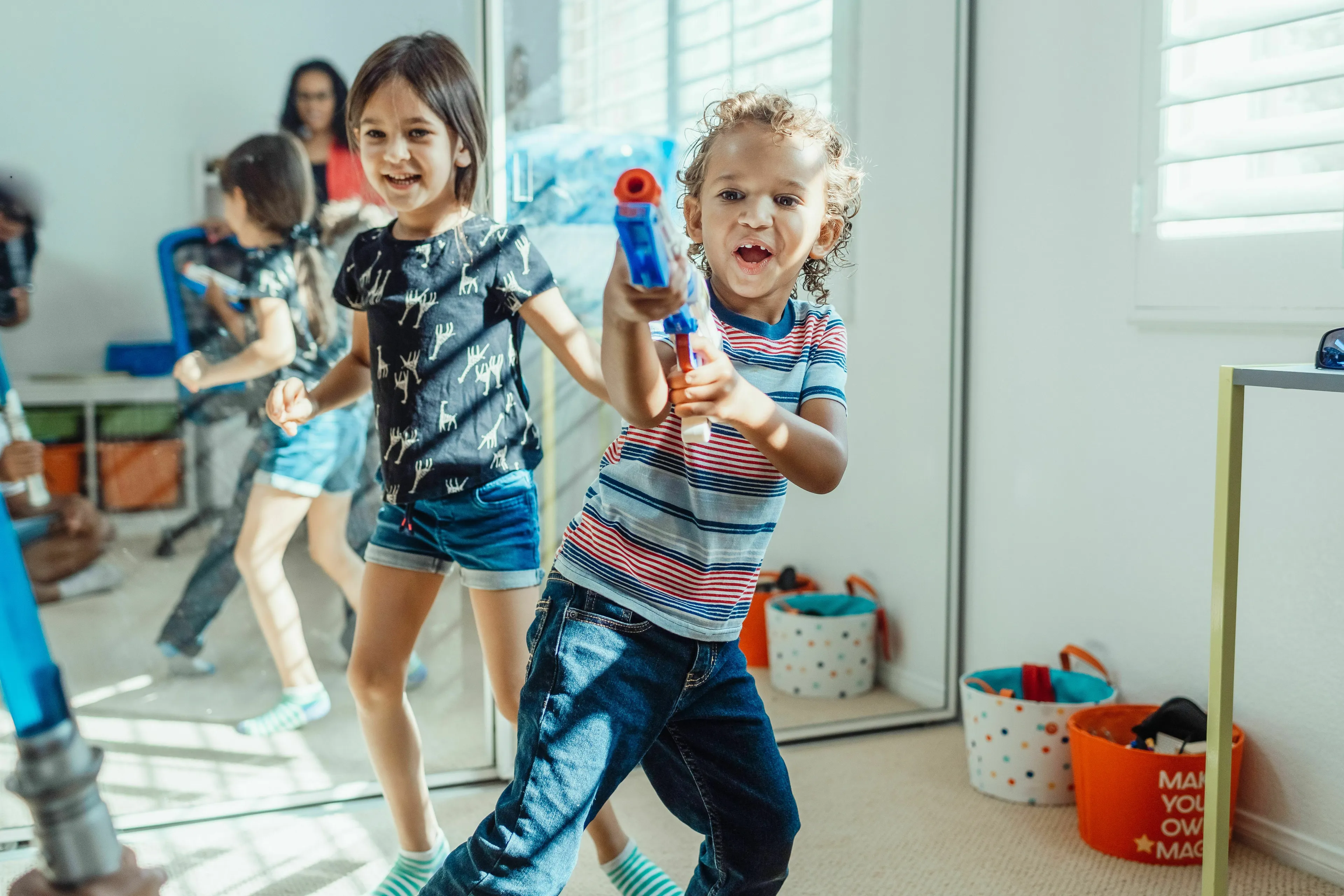 A young child points a toy gun, choosing a weapon of choice like a movie villain.