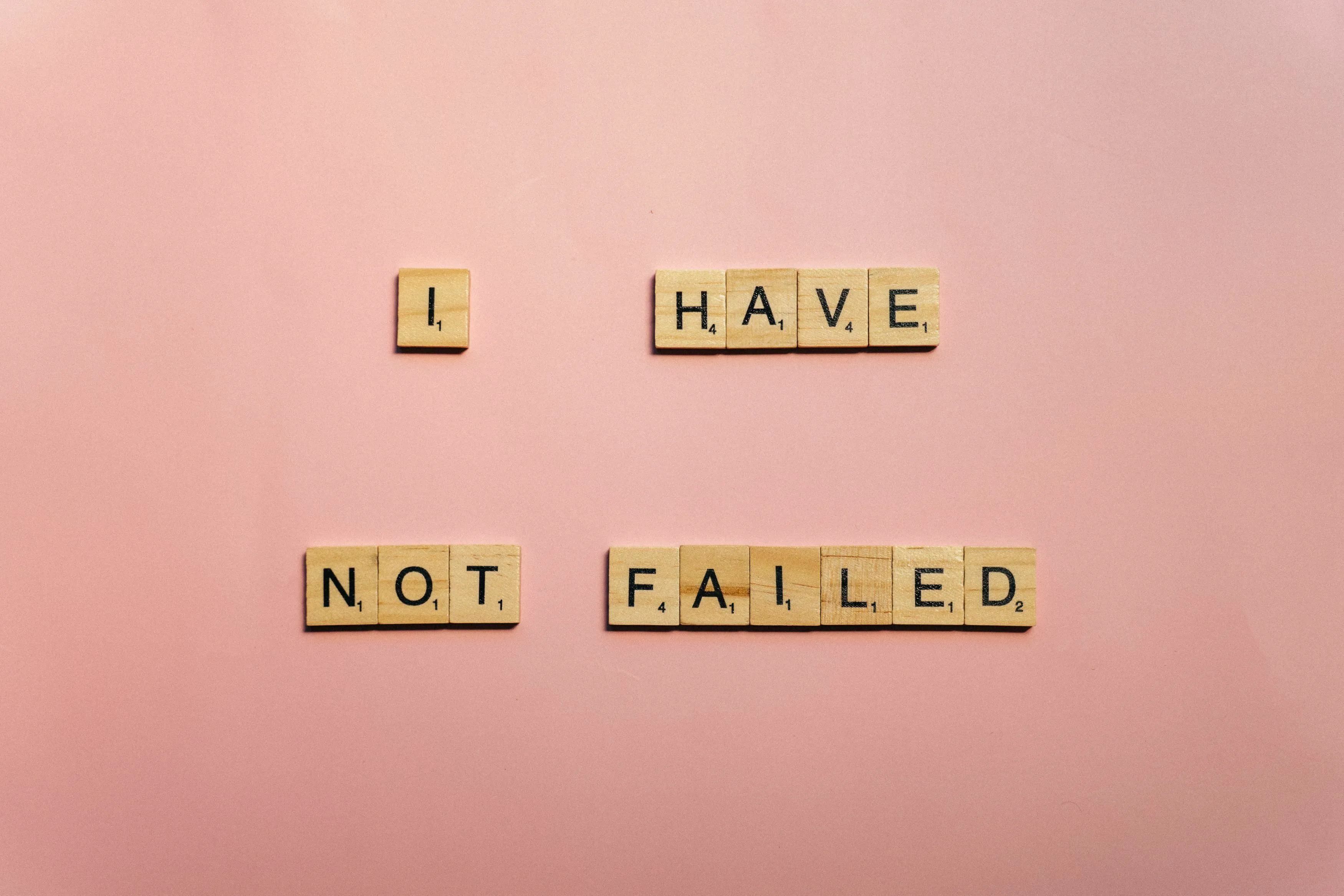 Scrabble tiles spelling out I have not failed, on a pink background, related to being underestimated.