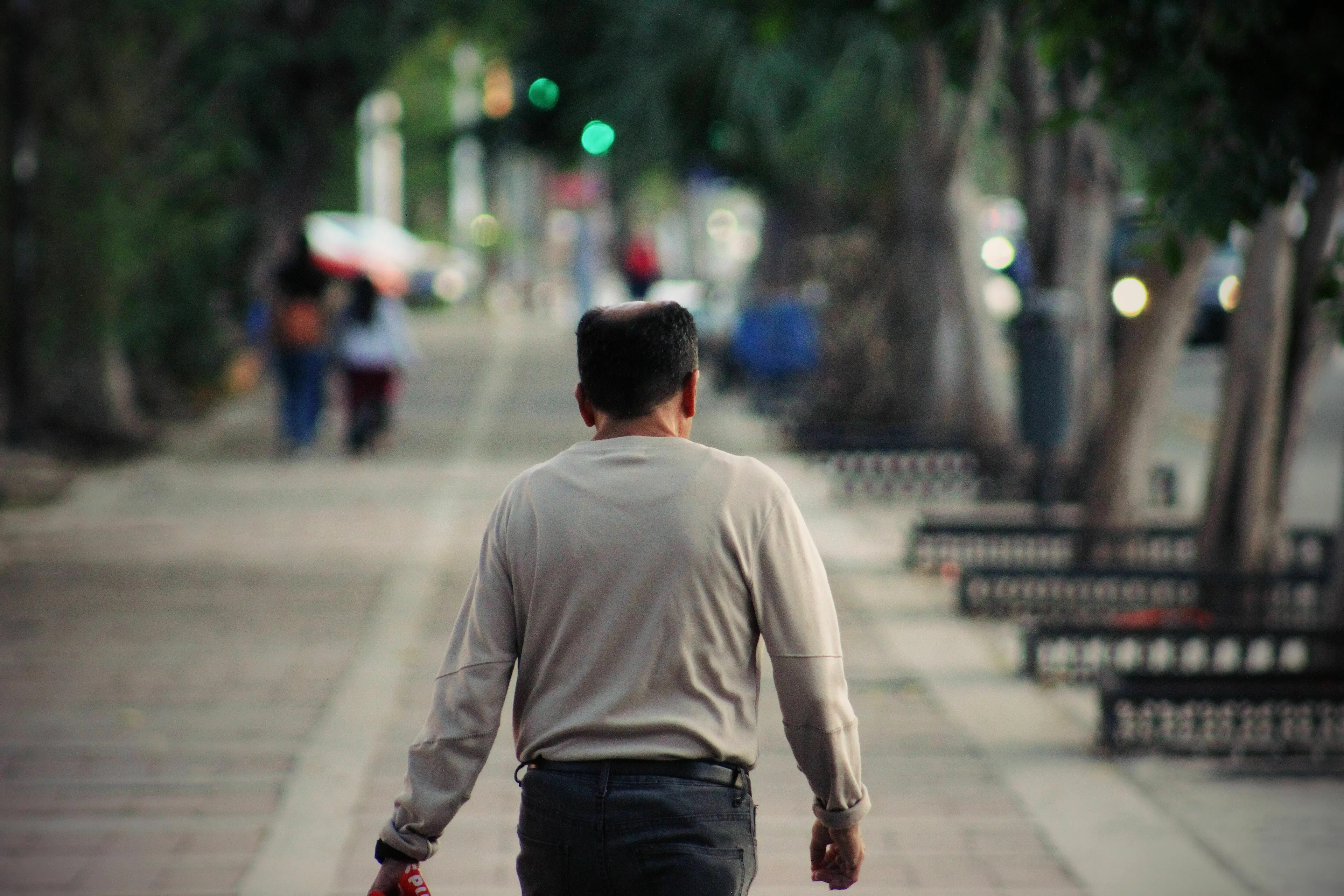Man walking away down a tree-lined path, contemplating a movie villain's choice to walk away.