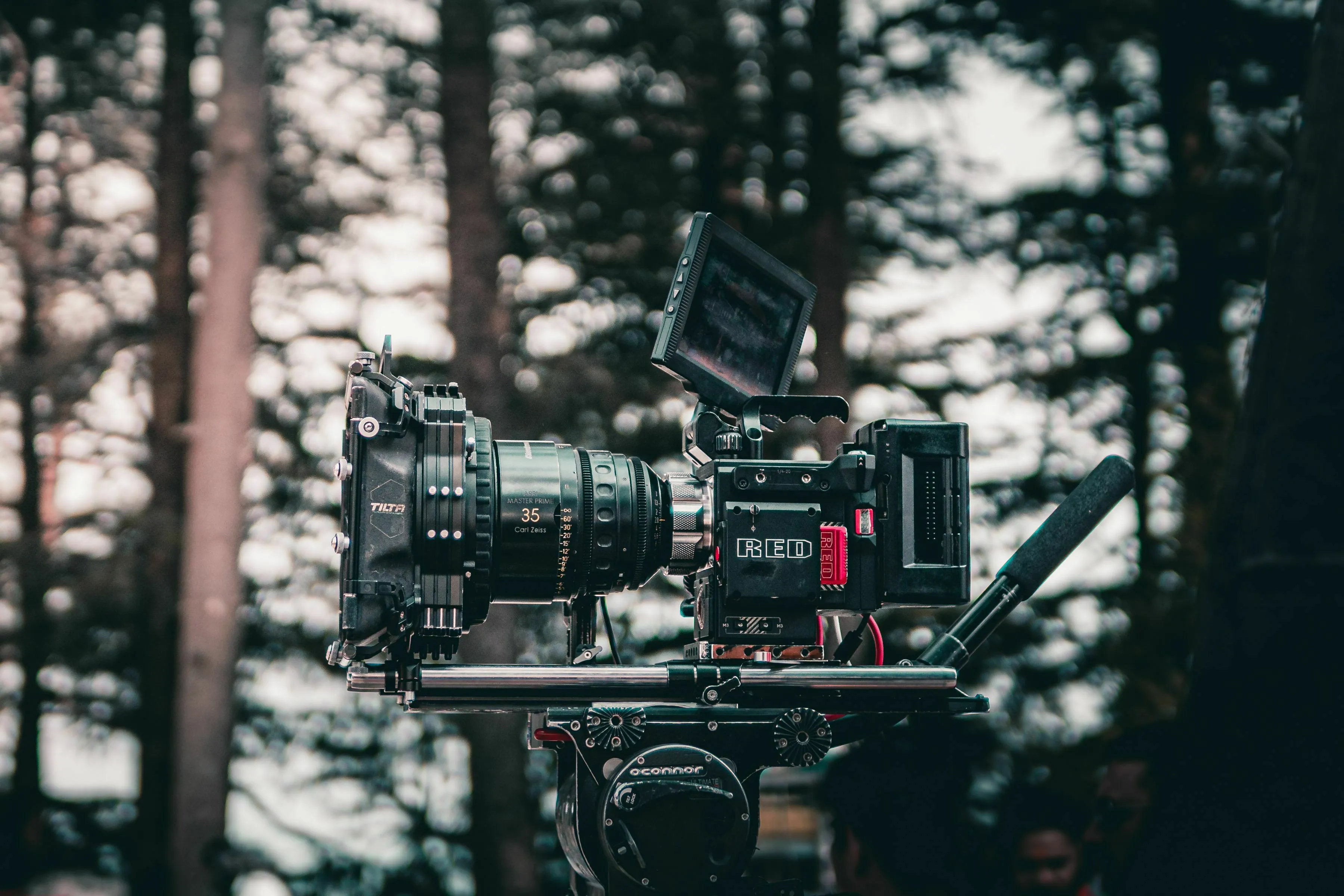 Professional movie camera set up outdoors in a forest, ready to capture a movie villain's final shot.