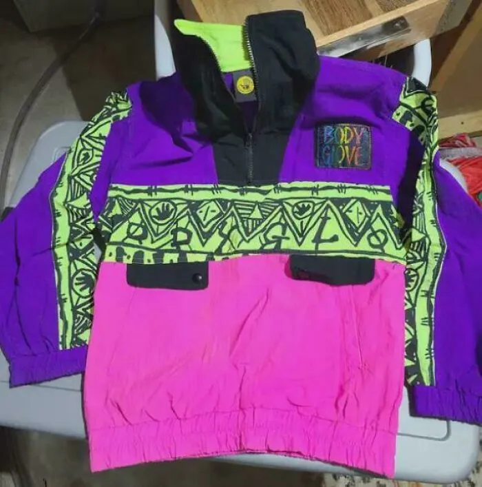 A vibrant 90s fashion jacket, purple, pink, and neon green, with tribal patterns, a quintessential 90s life item.