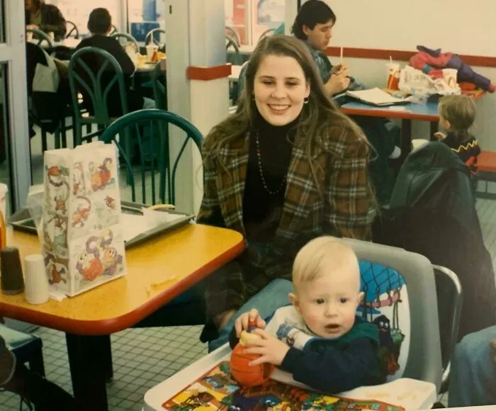 A mother and baby in a fast-food restaurant, capturing a candid moment of 90s life.