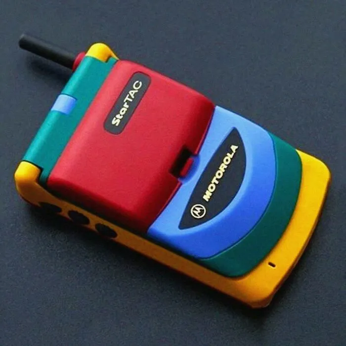 A colorful Motorola StarTAC phone, a vibrant artifact from life in the 90s, showcasing vintage tech.