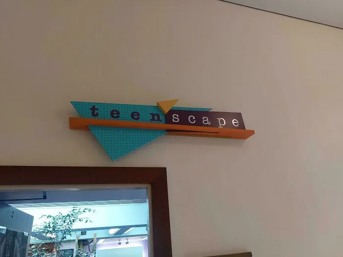 A retro sign for teenscape, with geometric shapes and bold text, characteristic of designs from life in the 90s.