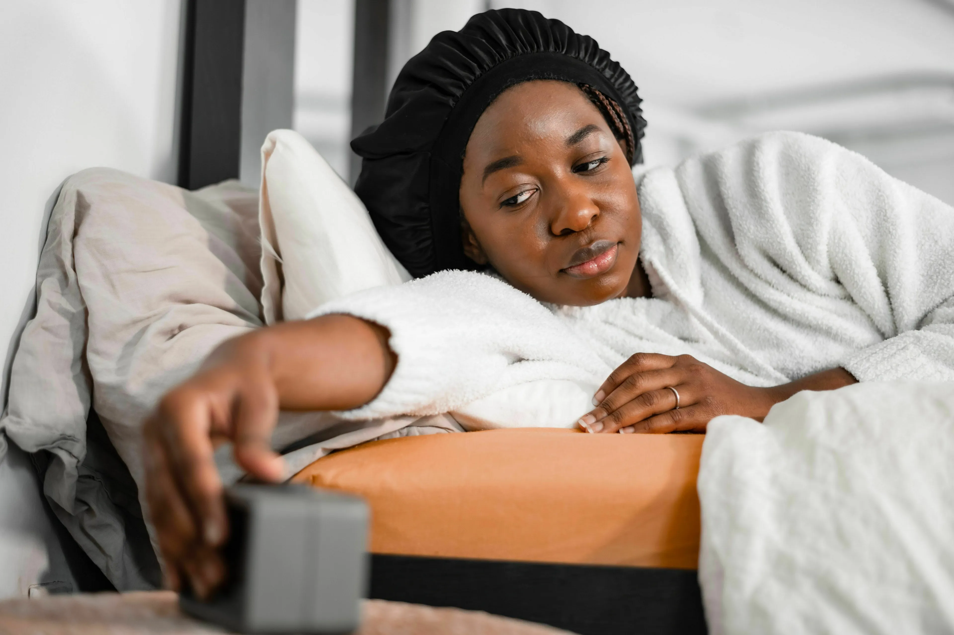 A woman turning off her alarm on a hard morning, revealing her stress response type.