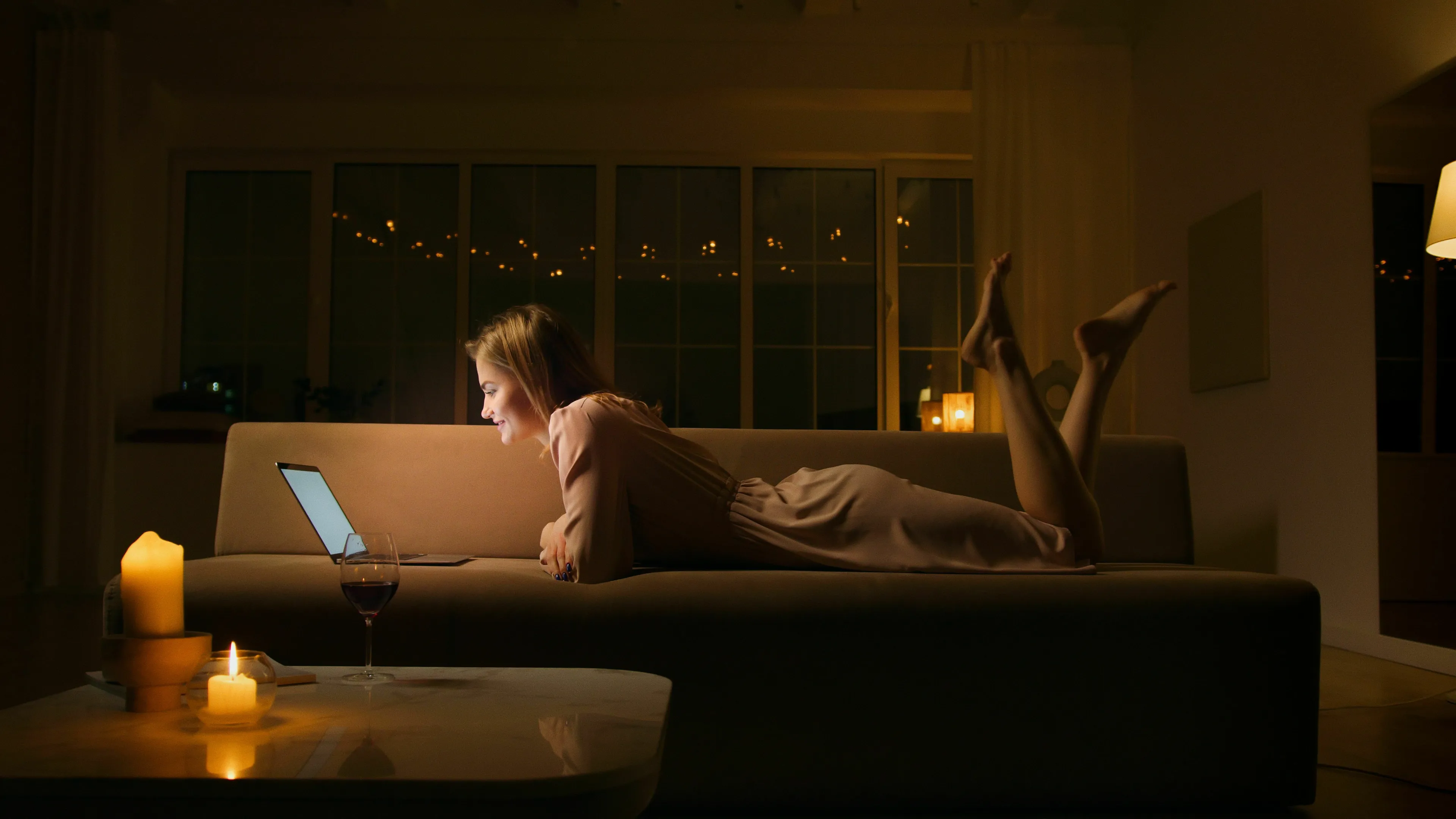 Woman lying on a couch with a laptop, reflecting on her Sunday night feelings and stress response type.
