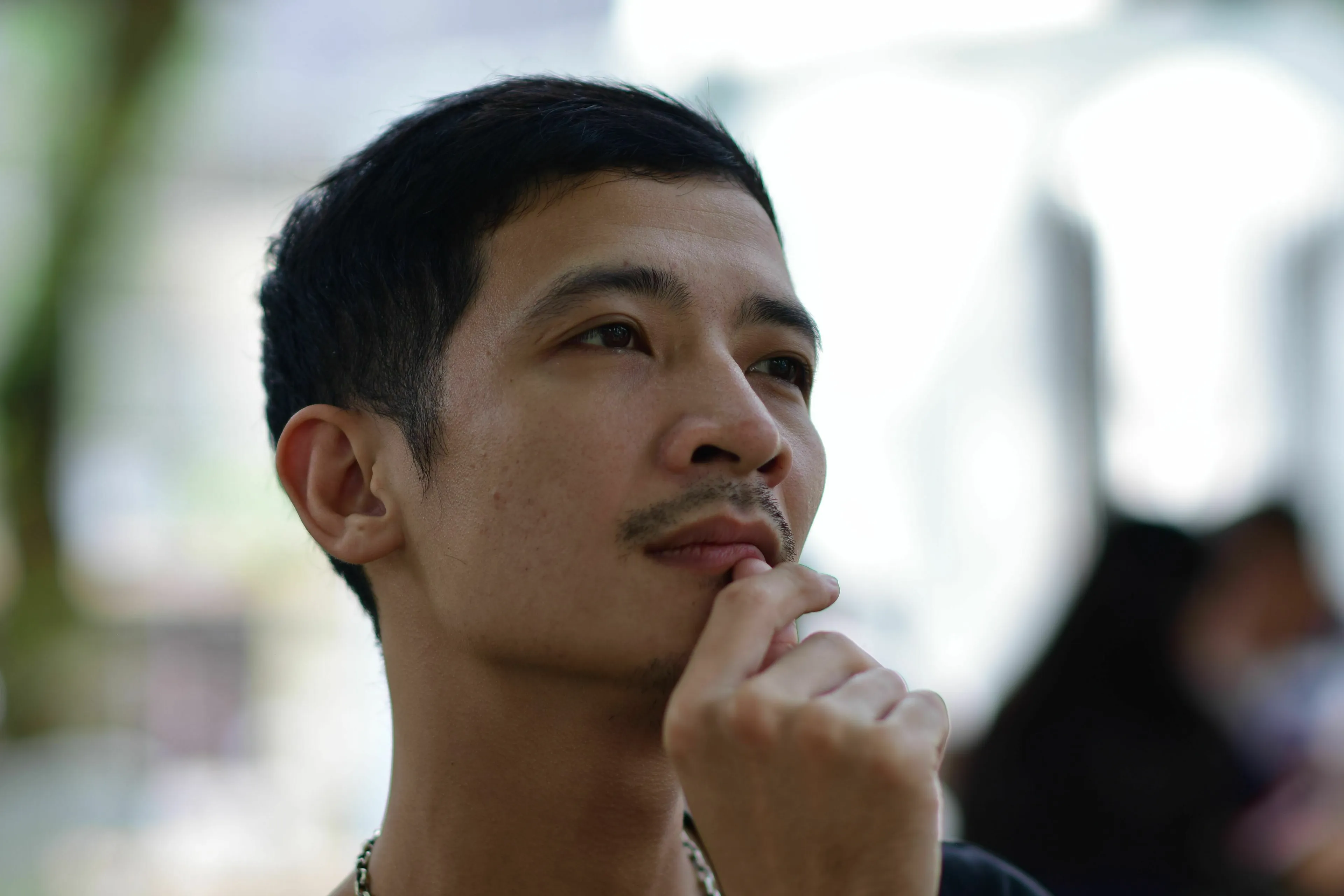 Man with hand on chin, thinking deeply about a big decision, revealing his stress response type.