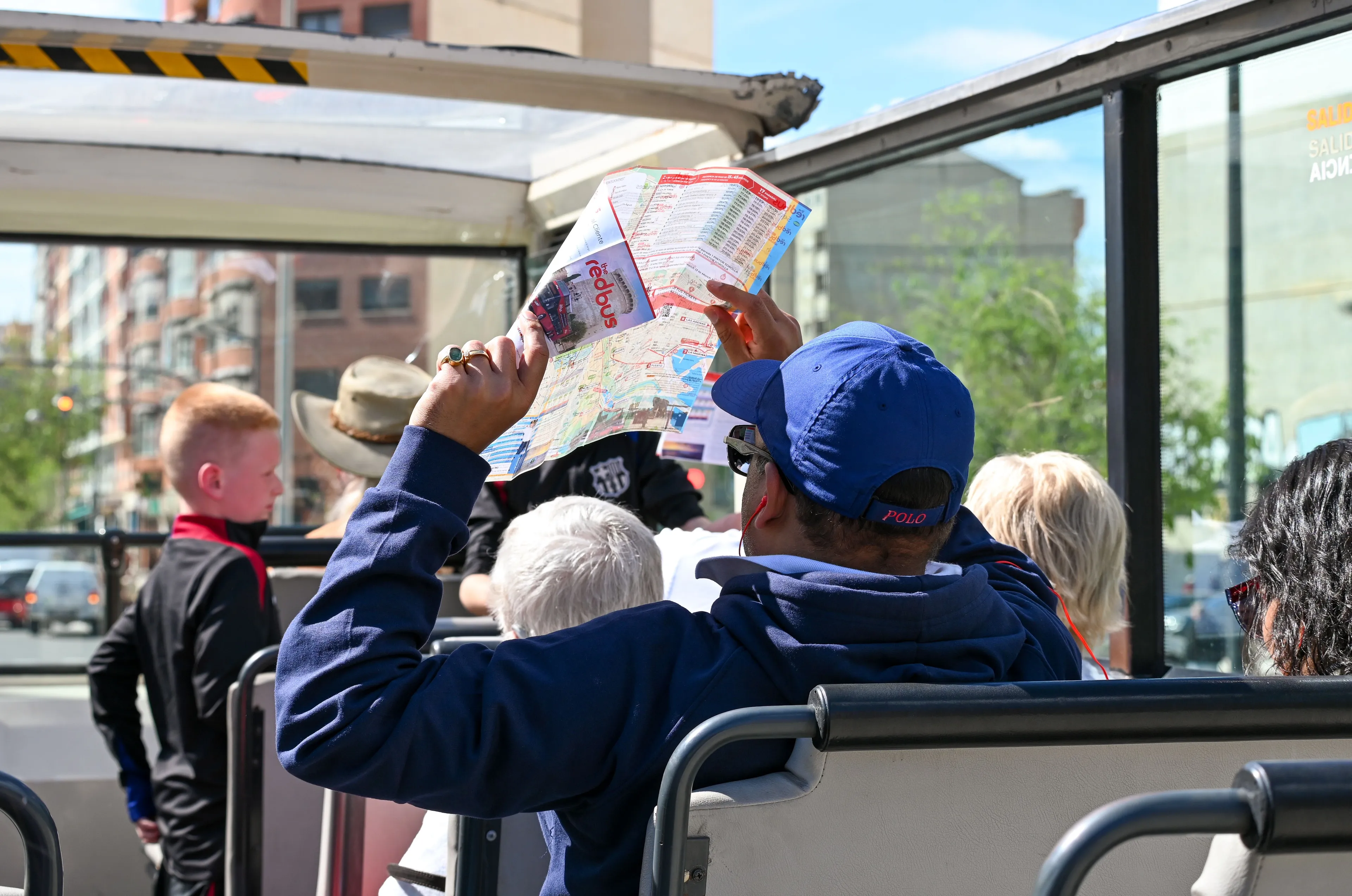 A person on a city tour bus looking at a map, picking a vacation spot.