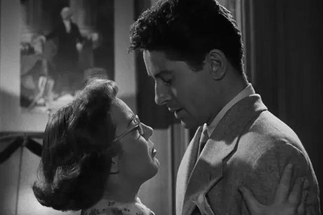 A man and a woman in an emotional embrace from the Hitchcock film Strangers On A Train.