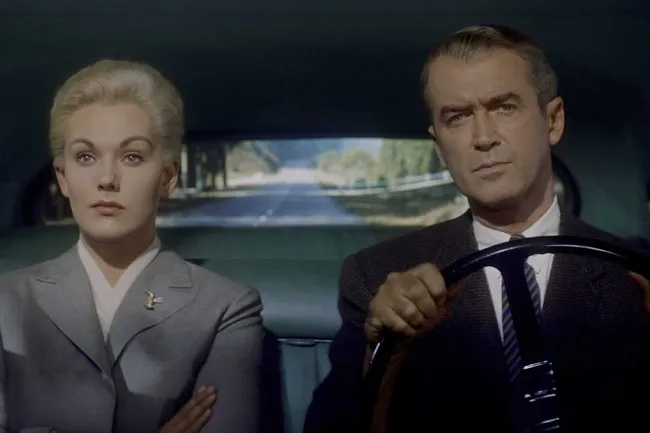 A scene from Hitchcock film Vertigo, featuring the lead actors in a car.