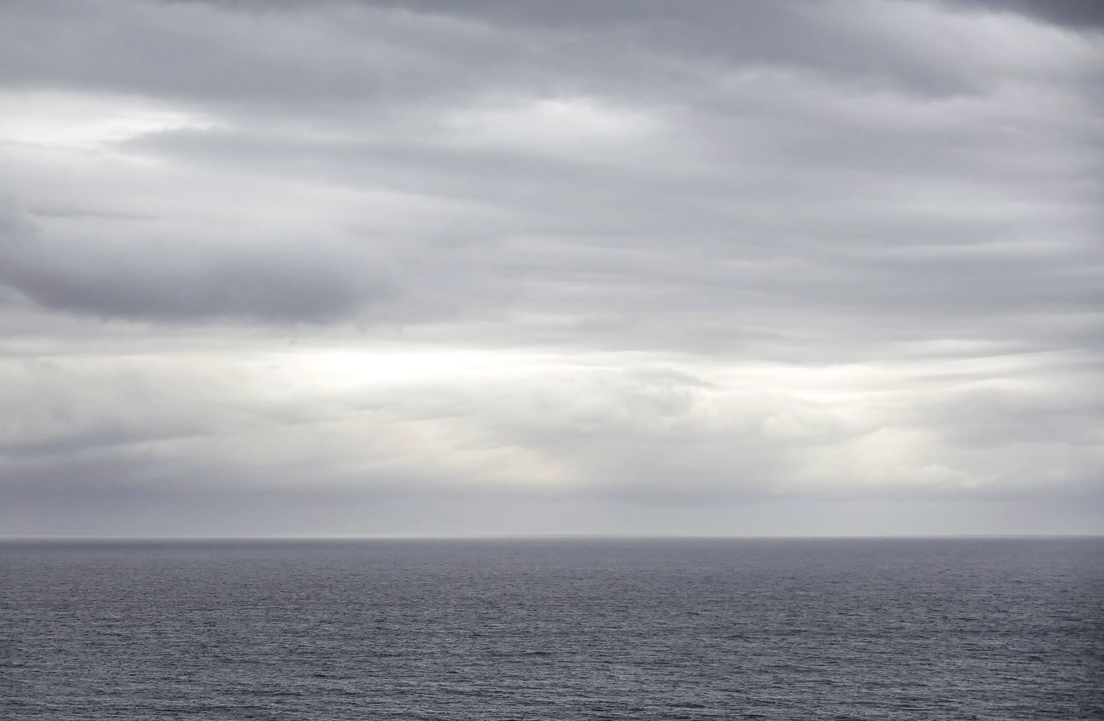 A vast grey ocean under a cloudy, grey sky, depicting a typical grey weather.