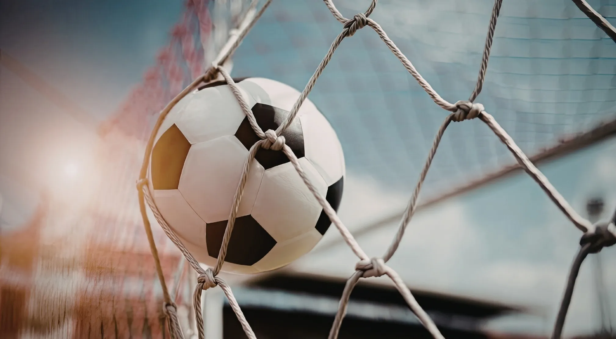 A soccer ball caught in the net of a goal, symbolizing the FIFA World Cup.