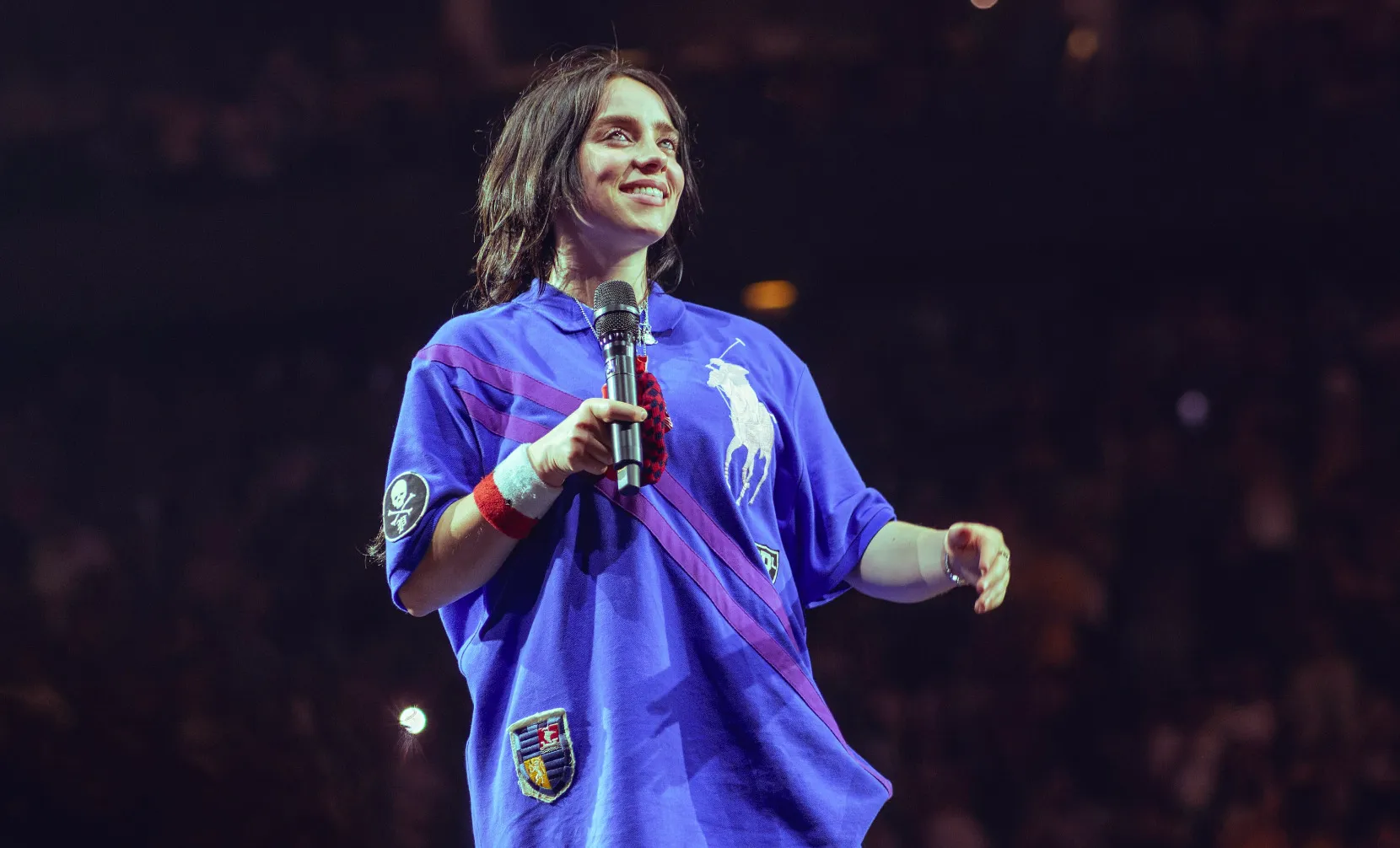 Billie Eilish on stage with a microphone, part of a quiz about her first name inspiration.