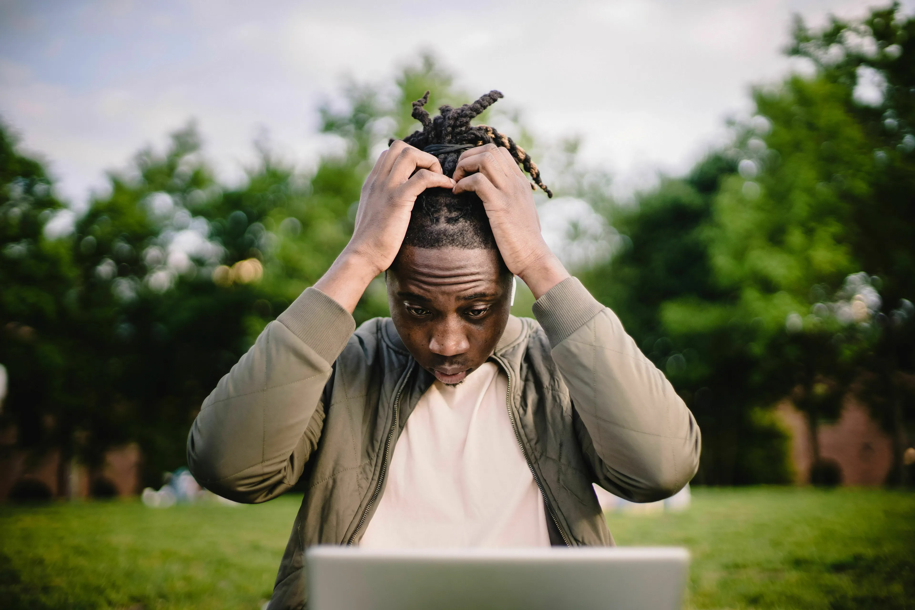 A man looking stressed at a laptop, contemplating his relationship with rules and how he feels about being wrong.