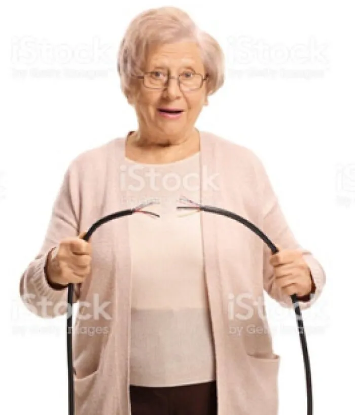 An elderly woman in glasses holding a deliberately cut cable, embodying an act of stupidity or confusion.