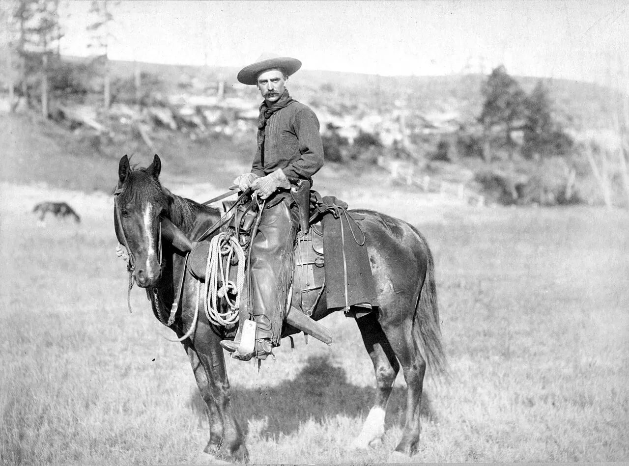 A rugged cowboy on horseback in the Wild West, a historical era known for adventure and independence.