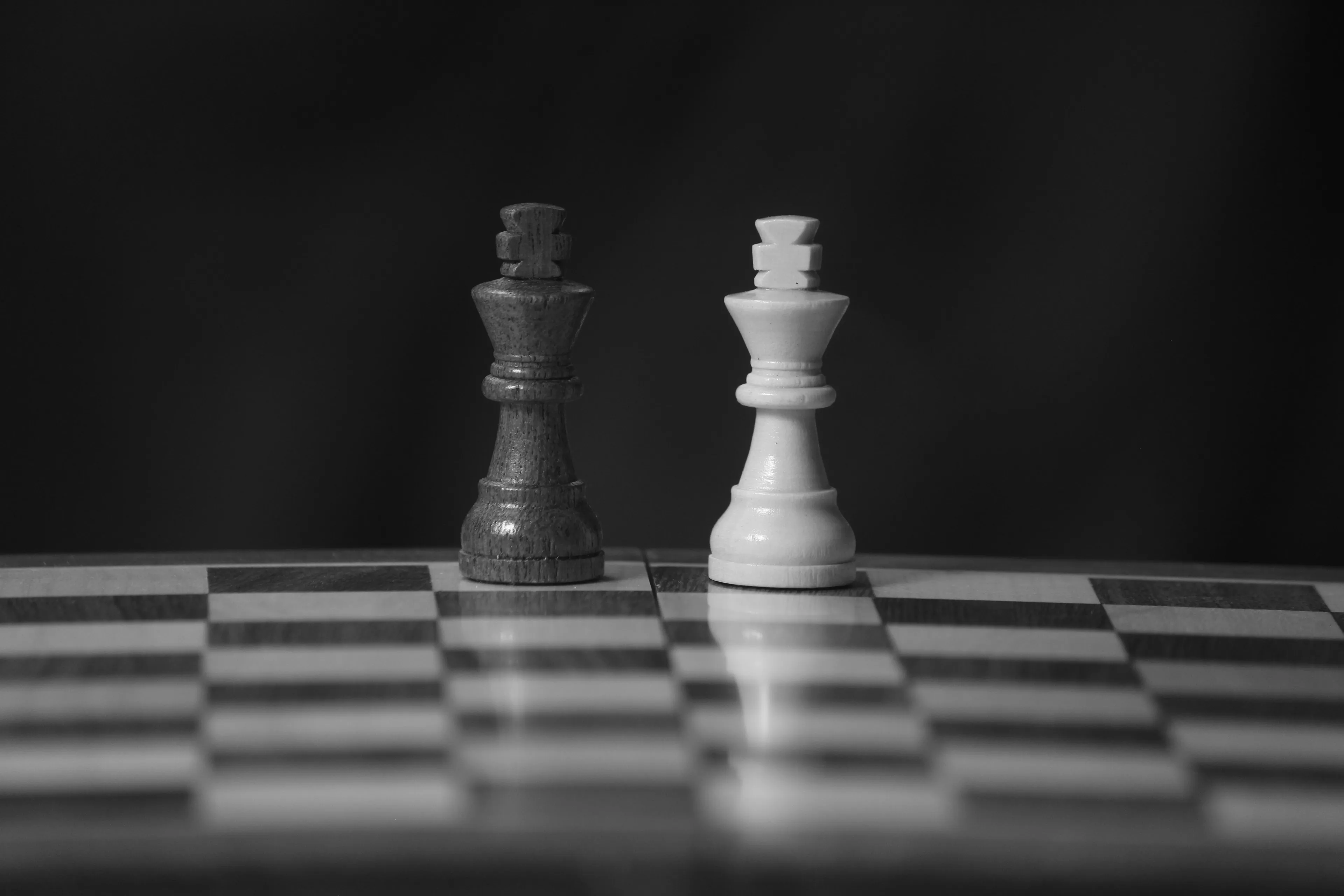 A black and white image of two chess kings on a board, depicting a childhood game of chess.