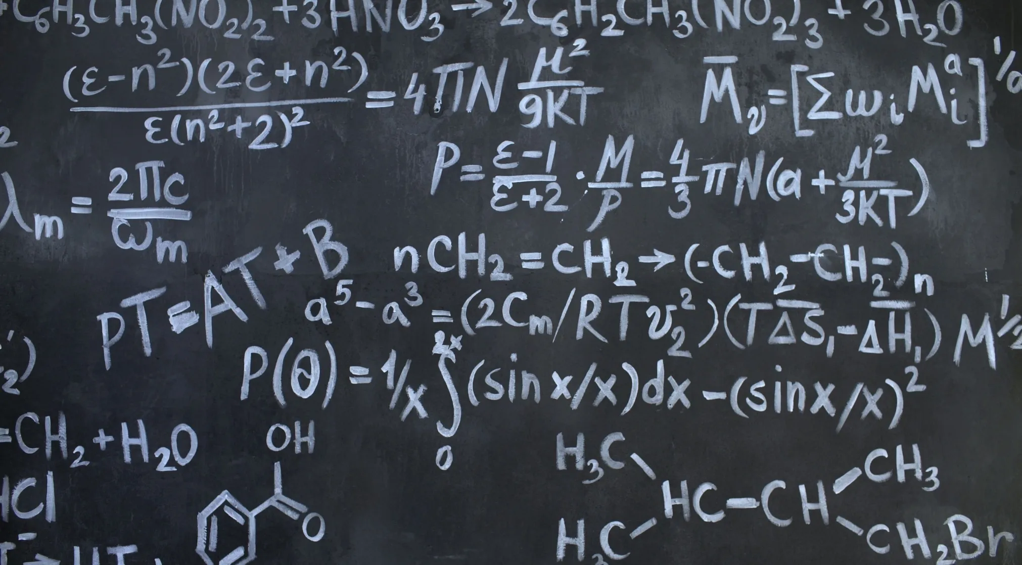 A blackboard filled with white chalk algebraic symbols and chemical equations. WWI Recruit Test: algebraic symbols.