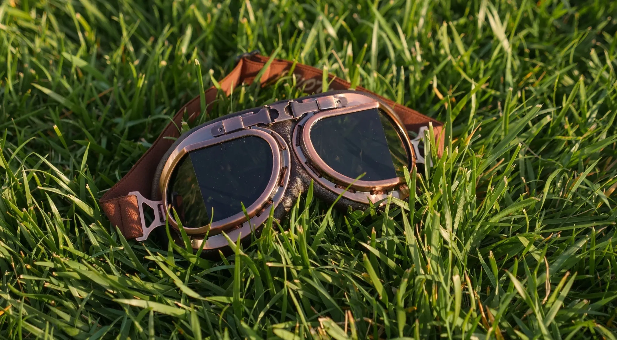 WWI Recruit Test goggles in the grass. Transparent goggles transmit light, shown with clear lenses on a sunny day.