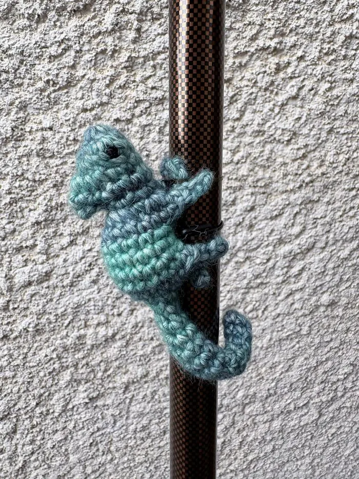 Small blue crochet seahorse wrapped around a pole