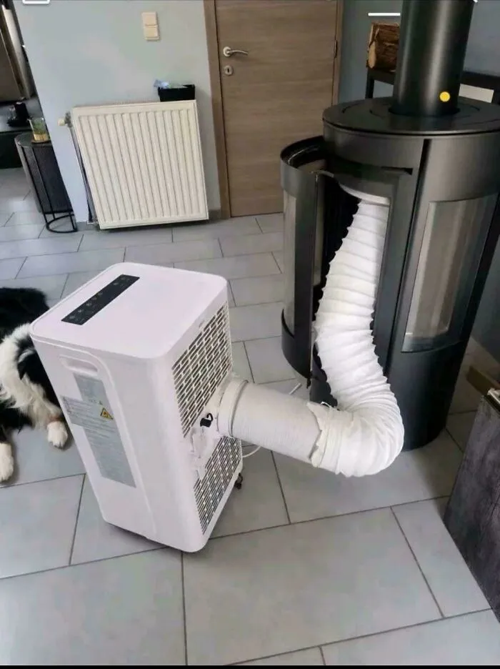 A portable air conditioner venting into a fireplace, a clever solution for cooling a room.