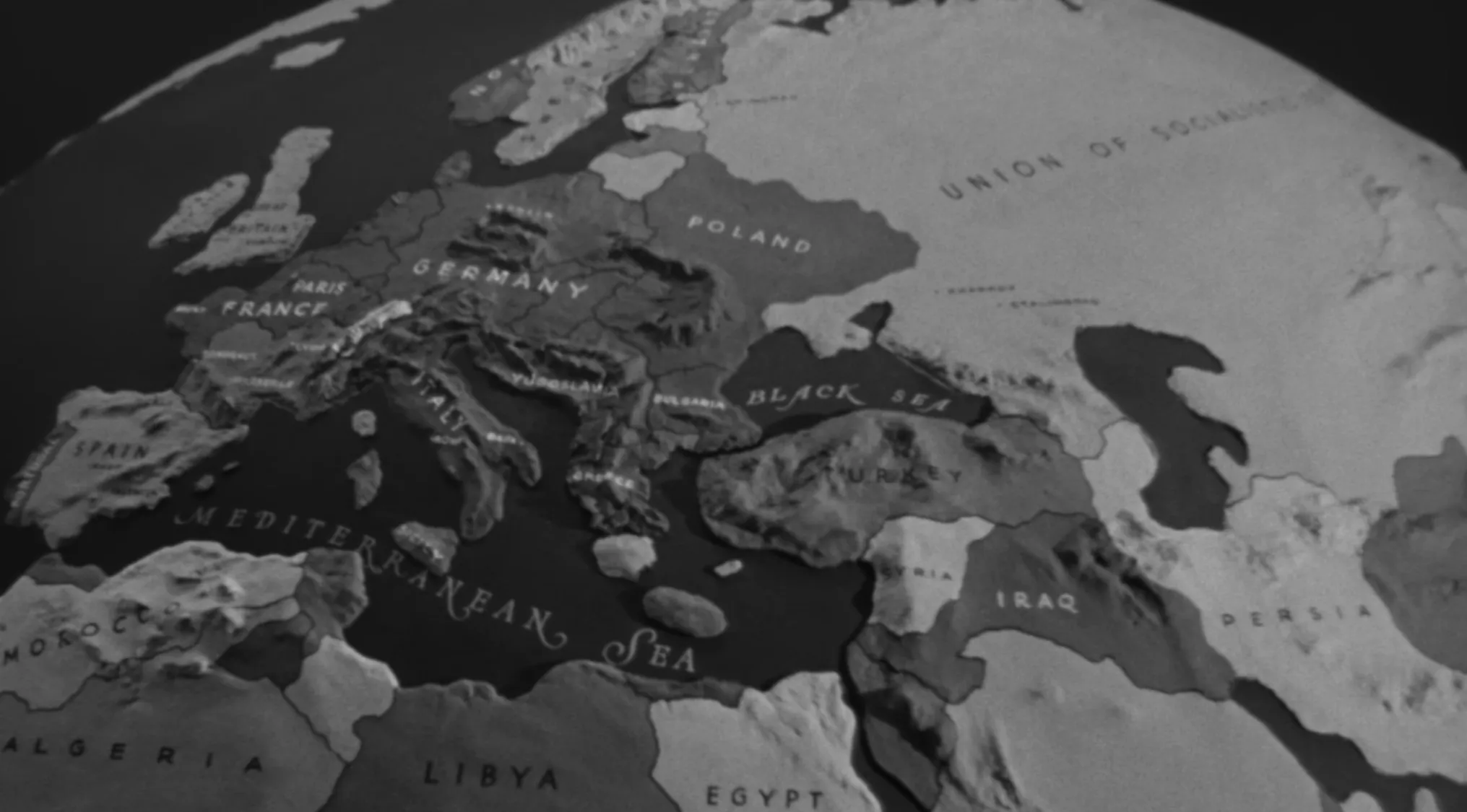A black and white image of a spinning globe showing the European refugee route in the opening movie scene of Casablanca.